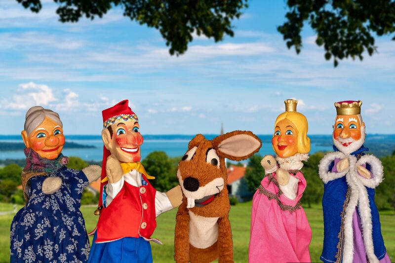Ein bairisches Kasperlspiel im Kurpark Bernau am Chiemsee Zuschauer sitzen überdacht im Musik-Pavillon